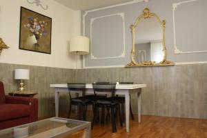 Appartamento blu centro storico في بولونيا: غرفة طعام مع طاولة وكراسي ومرآة