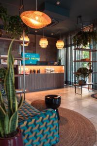 um lobby com uma planta e um bar em Hotel Jolly Roger em Pietra Ligure