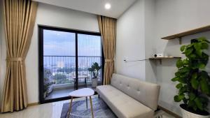 a living room with a couch and a large window at Bcons Garden Luxury Aparment in Dĩ An