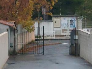 an open gate in a parking lot next to a building at La Maison de Dannie in Gardanne