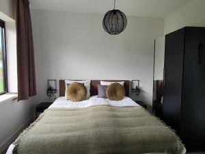 a bedroom with a large bed with two pillows at Nice water villa near forest, golf course and Veluwemeer in Zeewolde