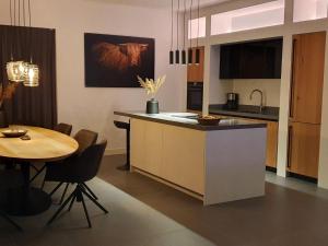 a kitchen and dining room with a table and a counter at Nice water villa near forest, golf course and Veluwemeer in Zeewolde