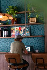 um homem sentado num bar usando um computador portátil em Hotel Jolly Roger em Pietra Ligure