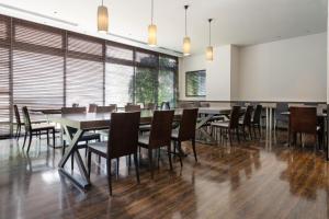 a dining room with tables and chairs and windows at Hotel Vista Ebina in Ebina