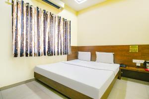 a bedroom with a large white bed in a room at FabHotel Satyug Jaisinghpura in Ujjain