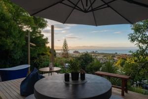 a patio with an umbrella and a table and chairs at Tosswill Road - Bay Vista in Nelson