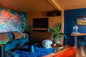 a living room with a blue couch and a tv at The Upside Down in Nelson