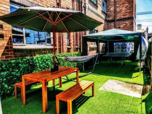 a table and a bench with an umbrella and a tent at Richmond Private Rooms - 151 Hoddle Homestay in Melbourne