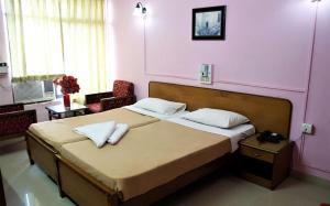 um quarto com uma cama grande e almofadas brancas em Margao Residency em Margão