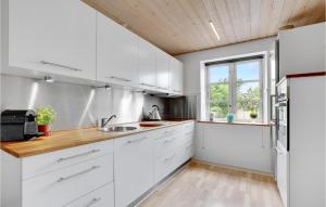 a kitchen with white cabinets and a window at Awesome Apartment In Hejls With Kitchen in Hejls