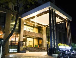 BNGV Mystic Premier Hotel في بانغالور: مبنى به دراجات نارية متوقفة خارجه في الليل