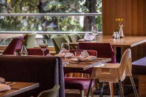 un restaurante con mesas y sillas y copas de vino en Hotel Gasthof Adler, en Lingenau