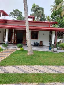 a house with a palm tree in front of it at Airport Dulux Green Villa in Minuwangoda