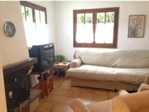 een woonkamer met een bank en een tv bij House with pool / Garden / BBQ BEACH in Tarragona