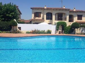 una gran piscina azul frente a una casa en House with pool / Garden / BBQ BEACH, en Tarragona