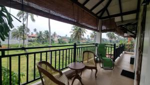 a balcony with chairs and a table and a view at Family Tides Guest in Kochchikade