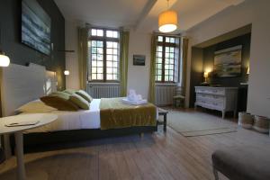 a bedroom with a bed and a dresser and windows at La Haute Flourie - bed and breakfast -chambres d'hôtes in Saint Malo