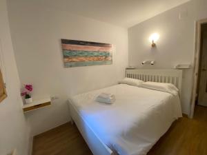 ein Schlafzimmer mit einem weißen Bett in einem Zimmer in der Unterkunft Apartamento Avet in El Tarter