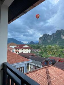 a kite flying in the sky over roofs at Jasmine Vangvieng Hotel in Vang Vieng