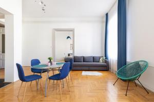 - un salon avec une table, des chaises et un canapé dans l'établissement SZ9 Szent István Apartment, à Budapest