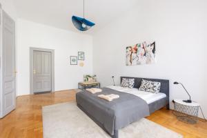 ein Schlafzimmer mit einem Bett und einer weißen Wand in der Unterkunft SZ9 Szent István Apartment in Budapest