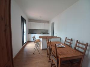 Il comprend une cuisine et une salle à manger avec une table et des chaises en bois. dans l'établissement Rest . . . Heliópolis, à Séville