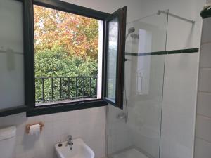 La salle de bains est pourvue d'une fenêtre, d'un lavabo et d'une douche. dans l'établissement Rest . . . Heliópolis, à Séville