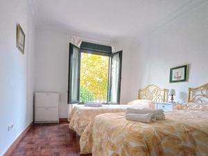 a bedroom with two beds and a window at Rest . . . Heliópolis in Seville
