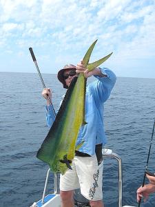 a man holding a fish on a boat at Nascer Do Sol - Chizavane in Xai-Xai