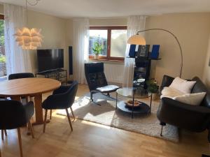 a living room with a couch and a table and chairs at Gästehaus Natur Wohnung Auszeit in Vöhl