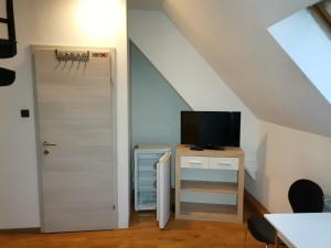 a room with a door and a tv on a dresser at Pension Prem in Kapfenberg