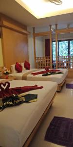 a group of four beds in a room at Lanta Summer House - SHA Plus in Ko Lanta
