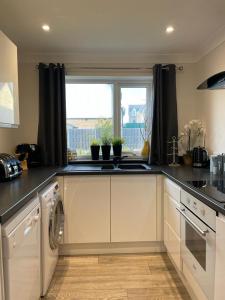 a kitchen with a sink and a dishwasher at Holiday home, Tywyn, newly refurbished, great location in Tywyn
