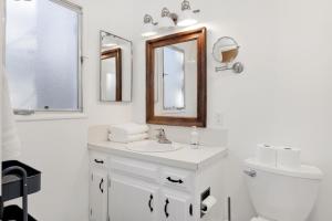 uma casa de banho branca com um lavatório e um espelho em 2153-The Cottage home em Big Bear City
