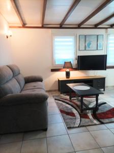 a living room with a couch and a table at Gîte De La Belle Vallée in Cleurie