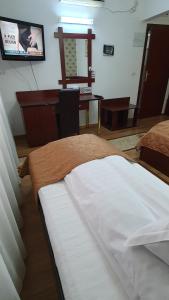 een slaapkamer met een bed, een bureau en een spiegel bij Pensiunea Select in Arad