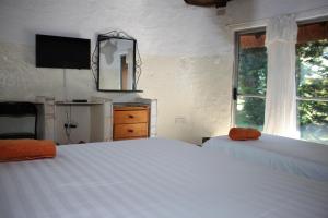 a bedroom with two white beds and a window at REED MAT LODGE in Lusaka
