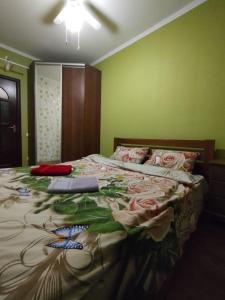 una camera da letto con un grande letto con fiori di Очеровательная квартира в центре города a Obukhiv