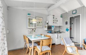 a kitchen and dining room with a table and chairs at Hus 30 A in Allinge