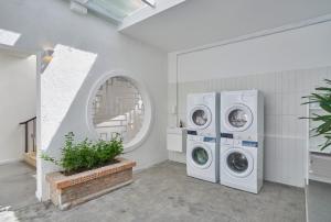 a laundry room with two washing machines and a window at M Village Cao Thắng 2 in Ho Chi Minh City