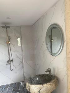 W łazience znajduje się kamienna umywalka i lustro. w obiekcie Floor river view w mieście Cat Tien