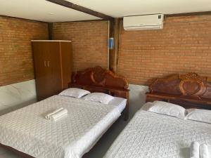 a room with two beds and a brick wall at Floor river view in Cat Tien