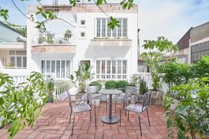 a patio with chairs and a table in front of a building at M Village Cao Thắng 2 in Ho Chi Minh City