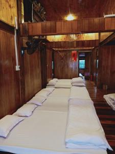 a row of white beds in a room at Ba Be Green Homestay in Bak Kan