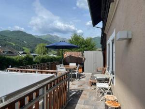 balkon ze stołami, krzesłami i parasolem w obiekcie Kunstwerk AppARTement w mieście Sankt Michael im Lungau