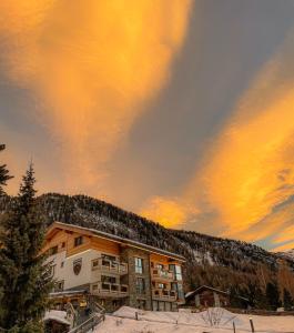 ein Gebäude im Schnee mit Sonnenuntergang in der Unterkunft Panorama Ski Lodge in Zermatt