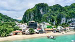 a town on a beach next to the water at H Hotel El Nido - Vegan Friendly Hotel Managed by H Hospitality Group in El Nido