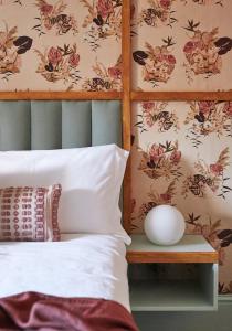 a bedroom with a bed with a flower wallpaper at The George & Heart House in Kent