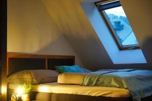 Bett in einem Zimmer mit Fenster in der Unterkunft Rooftop Residence in Wien