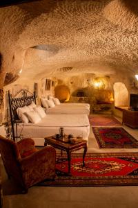 ein Schlafzimmer mit 2 Betten und einem Tisch in einer Höhle in der Unterkunft Cave Art Hotel Cappadocia in Ürgüp